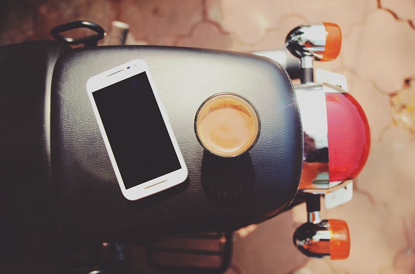 Moto avec un téléphone mobile et le café